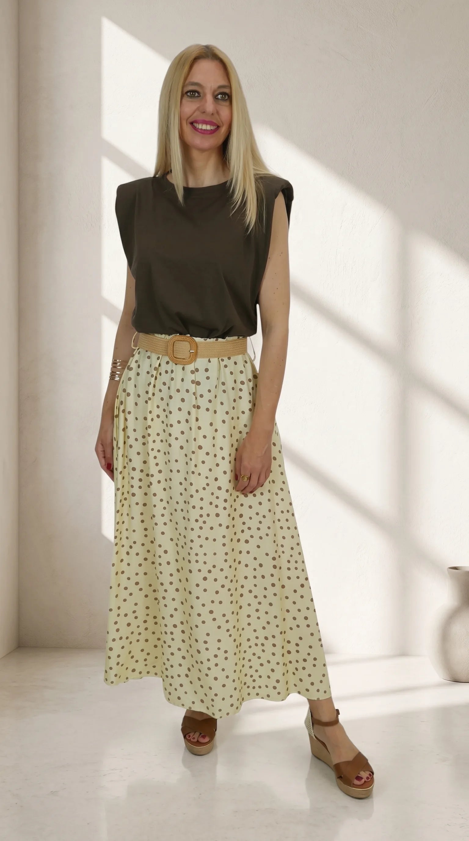 Look Camiseta Hombreras con falda midi de lunares y cinturón de rafia.