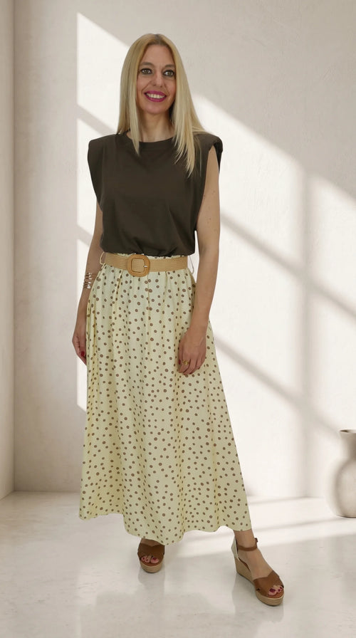 Look Camiseta Hombreras con falda midi de lunares y cinturón de rafia.