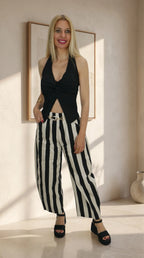 Look de top halter negro con nudo frontal combinado con pantalón de rayas negro y blanco
