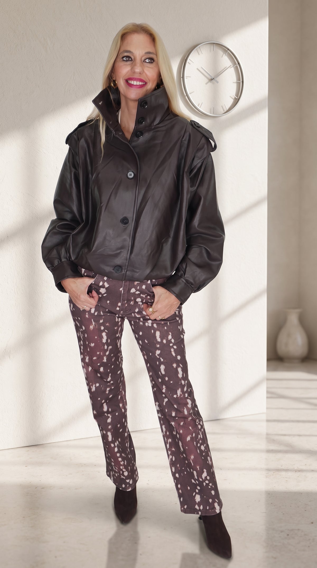 Modelo con chaqueta marrón efecto piel de bajo fruncido y jeans Bambi de estampado moteado.