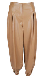 Pantalón globo efecto piel en color camel, con tiro alto, pinzas delanteras y bajos fruncidos.